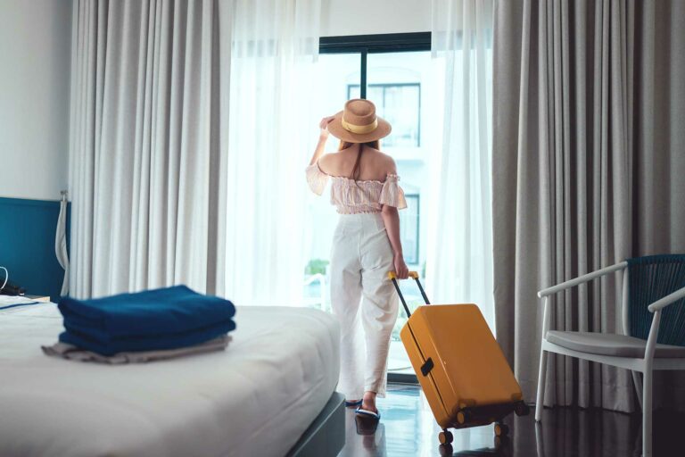 Woman with suitcase in hotel room